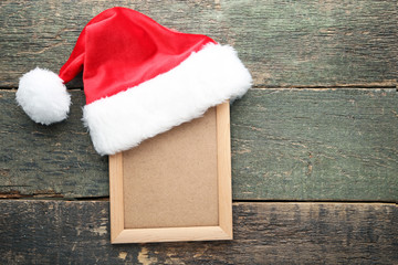 Obraz na płótnie Canvas Red santa hat with photo frame on grey wooden table