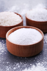 White sea salt in bowls on grey wooden table