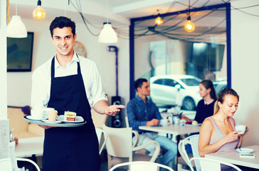 Male waiter is warmly welcoming guests