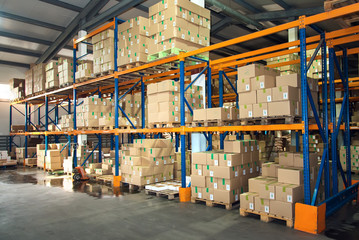 Large hangar warehouse of industrial and logistics companies. Long shelves with a variety of boxes.