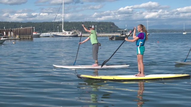 Four people standup paddleboarding