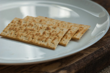 several cookies cracker on a white plate on a wooden background