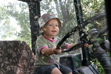 Very little white boy in a plaid Panama sits behind the wheel of the tractor. baby like to sit in my father's cab and turn the steering wheel. Photos white child in the tractor cab