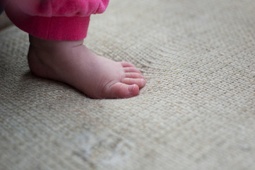 The legs of a little girl close-up on a neutral background.