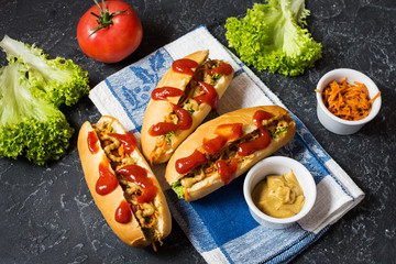 Hot dog with pickles and lettuce on concrete background