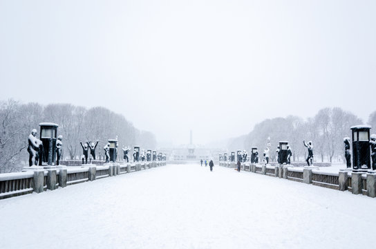 OSLO, January 2015. Some people walking during a snow fall in Vigeland sculpture park or Vigelandpark in Oslo, Norway. Vigeland is located in the Frognerpark in Oslo