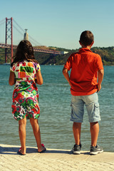 Kids looking at river Tejo on a beautiful sunny afternoon. Taken in Lisbon, Portugal.