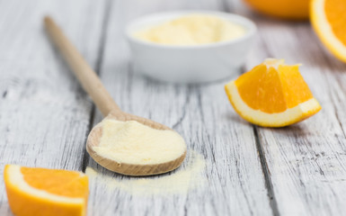 Wooden table with orange fruit powder (selective focus)
