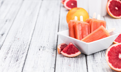 Grapefruit Popsicles (selective focus) on a vintage background