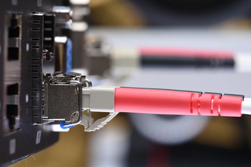 Network devices technology, optical fiber cable and switch, close-up on black background