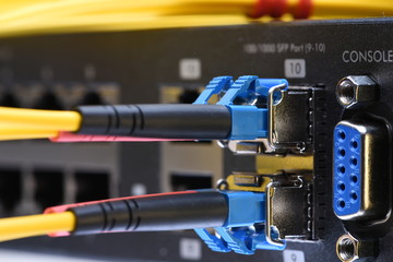 Network optic fiber cables and switch in data center close-up