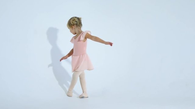A small ballerina dances with enthusiasm. The girl is engaged in ballet