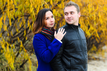 Fototapeta premium The guy with the girl walking in the Park , in a good mood. dressed in jackets, autumn time.