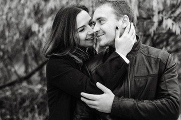 The guy with the girl walking in the Park , in a good mood. dressed in jackets, autumn time.