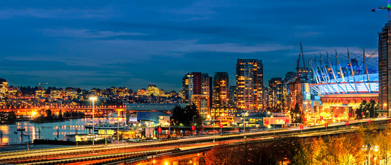 Fototapeta premium Night life of a huge seaside city with modern shining multicolored neon lights skyscrapers, top view