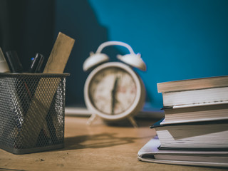 vintage books and alarm clock on the table isolated macro