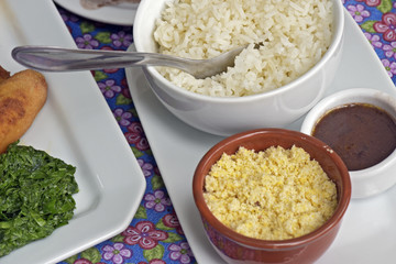 Accompaniments of feijoada served at the table