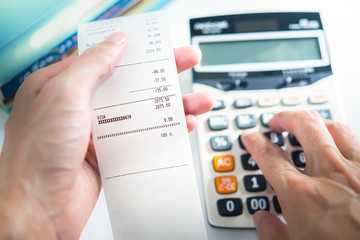 Grocery shopping list in hand with calculator - money account management concept