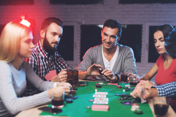 Young people play poker at the table.