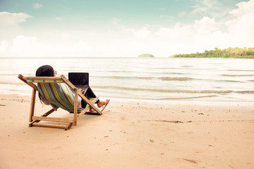 Fototapeta na wymiar Business woman using a laptop beside the beach