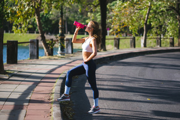 Girl drinking from a shaker in the Park