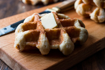 Belgium Waffle with Butter on wooden surface.