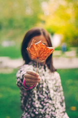Girl holding a leaf in front of her face