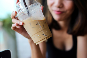 Portrait of smiling beautiful woman drinking cold coffee