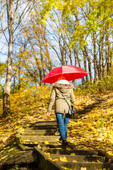 Woman walking in park with umbrella