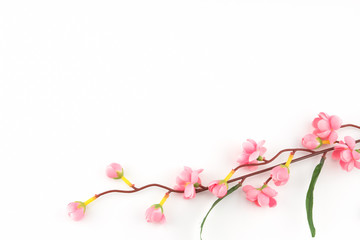 Fake pink flower branches on white background with copy space
