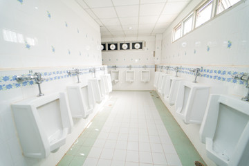 row of urinals men public toilet