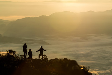 Silhouette of group people standing on the mountain and take photos at sunrise., at Doi Luang Chiang Dao Chiang Mai Thailand, silhouette concept