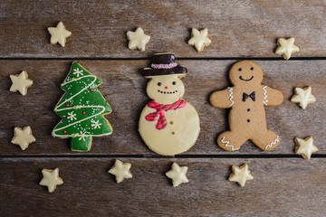 Festive Christmas Cookie and New Year in the shape of Christmas tree, Gingerbread man, snowman, Snowflake, star on wooden table