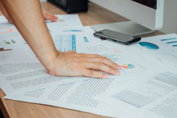 Close up hand of Analysis business accounting on sheets. Businessman hand working on analyzing investment charts, financial ,turnover at working space ,business concept