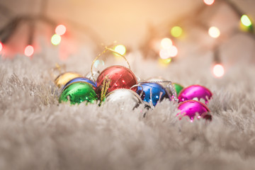 Christmas ball on white carpet with colorful bokeh light background