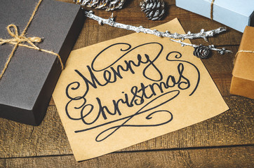 Boxes with gifts, cones, text "Merry Christmas"  on a wooden background