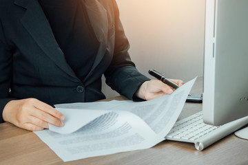 Businesswoman reading and checking terms and conditions document on her desk, business concept