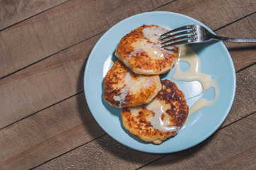 Appetizing sour cream with cream on a blue plate on a wooden dark background