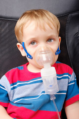 Boy making inhalation with a nebulizer