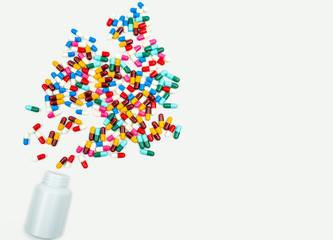 Pouring antibiotics capsule pills into plastic bottle on white background with copy space. Drug storage, antibiotic drug use with reasonable, health policy and health insurance concept.