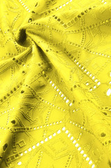 texture, pattern. Cloth is yellow dense with perforated holes. Perforated with a delightful design, ripe for conversation. Providing an extremely soft surface texture along with flexible drapery,