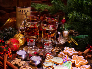Christmas table with punch and hot wine. Xmas decorations and candles in composition. Pine branch and holiday cookies.