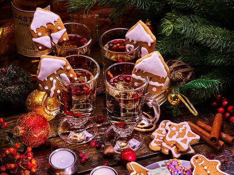 Christmas table decorations with glasses of punch and gingerbread cookies, bottle of wine in background. Xmas arrangement top view.