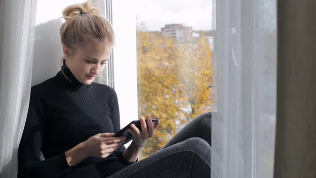 Blonde woman reading a book in e-reader