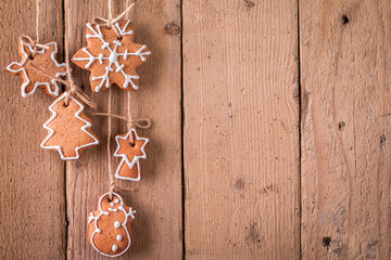 Christmas gingerbread hanging over wooden background