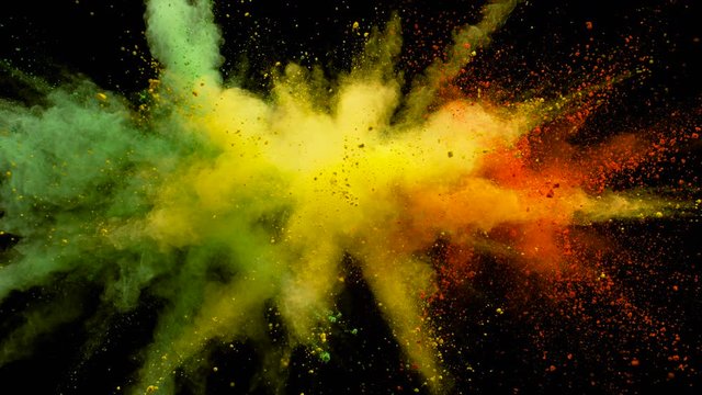 Colorful powder/particles fly after being exploded against black background. Shot with high speed camera, phantom flex 4K. Slow Motion.