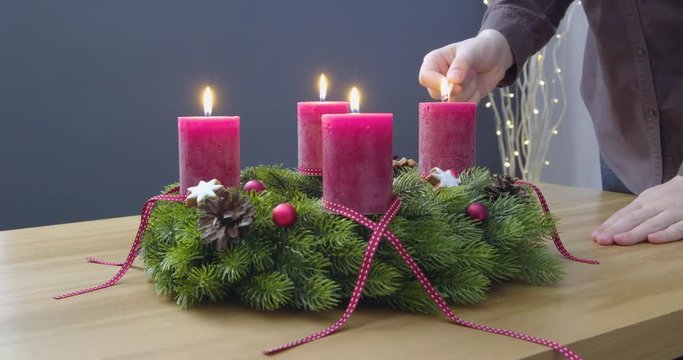 Fourth Sunday of Advent - a young woman is lighting the fourth candle of the advent wreath - ProRes