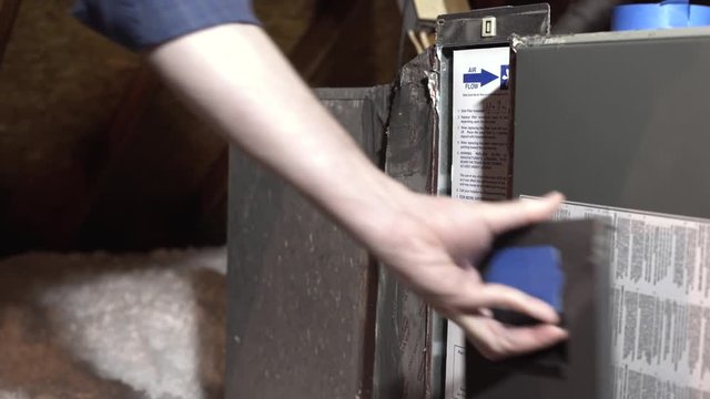 homeowner replacing the whole house air conditioning filter in attic 4k