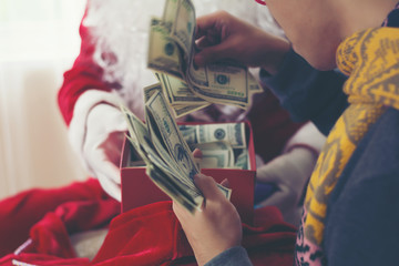 Happy man pulls gift out Santa Claus and have money inside.