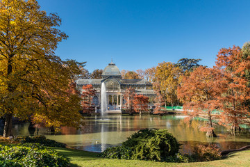 Fototapeta na wymiar Palacio de Cristal in the Retiro Park in Madrid, surrounded by autumn colors